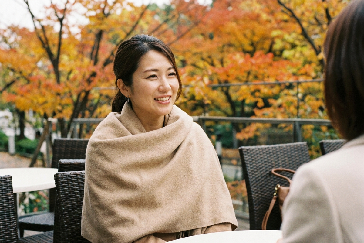 秋のカフェで大判ストールを羽織る女性のイメージ